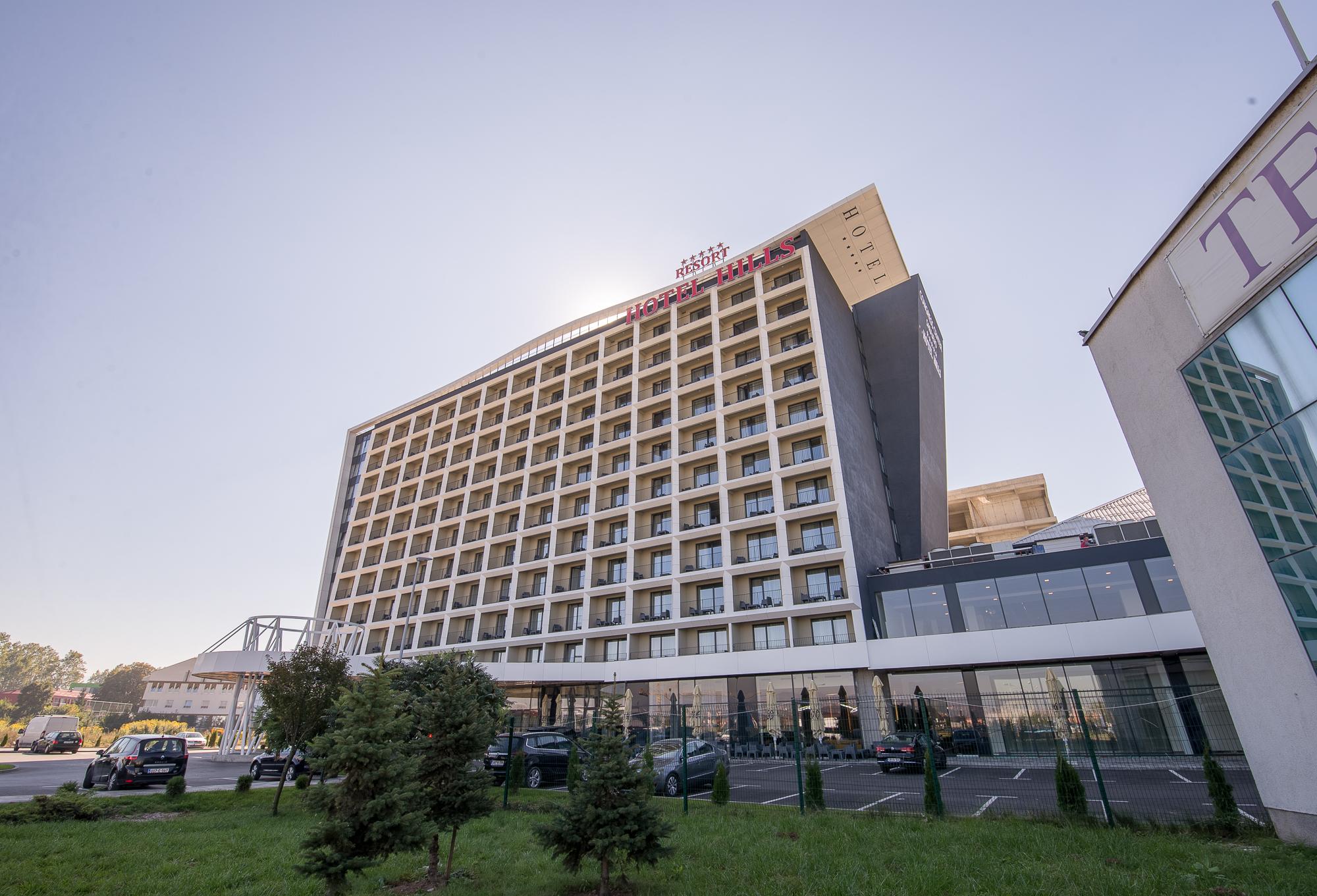 Hotel Hills Sarajevo Congress & Thermal Spa Resort Ilidža Εξωτερικό φωτογραφία The photo shows a modern hotel building with multiple floors and a contemporary design. The structure features large windows arranged in a grid pattern and a prominent entrance area at the bottom. There are green areas, possibly with trees or landsca